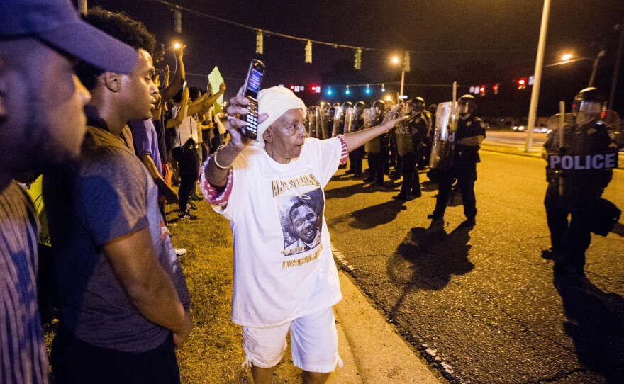 People gather to protest the shooting of Alton Sterling on Sunday in Baton Rouge, La.