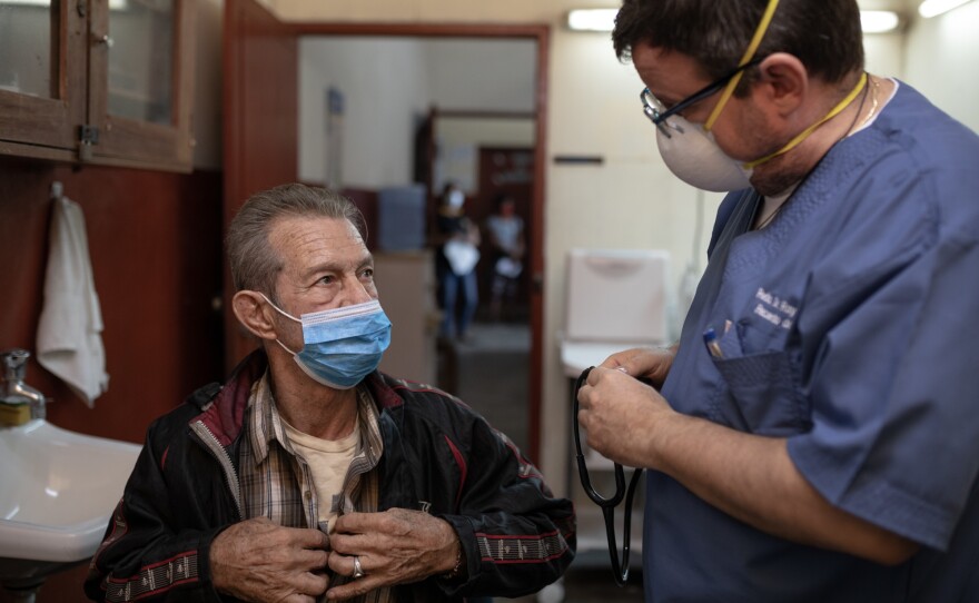Raymond Portelli, priest and doctor, treats a patient in his clinic inside the San Martin de Porres church in Iquitos, Peru.
