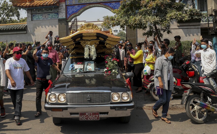 Bystanders flash a three-fingered sign of resistance as the body of Kyal Sin leaves the Yunnan Chinese temple in Mandalay, Myanmar earlier this week.