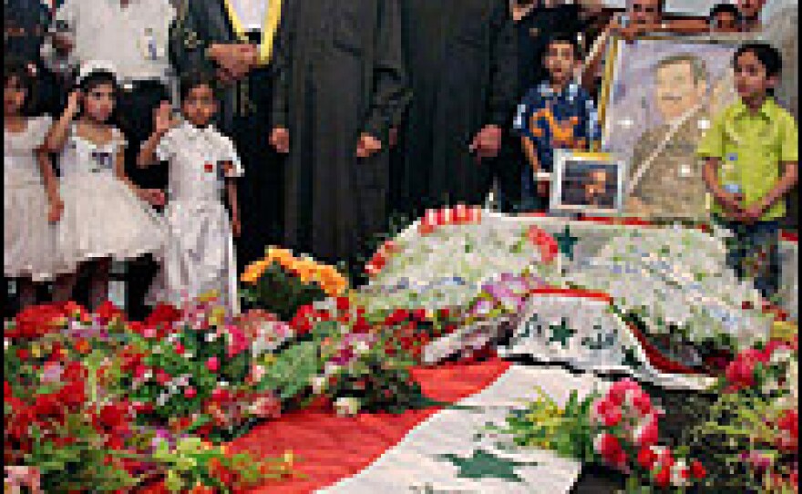 Iraqis gather around the tomb of Saddam Hussein.