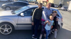 Michelle McClintic stands in front of her new car with kids Taylor, Savannah and MaKayla near downtown, Nov. 1, 2019.