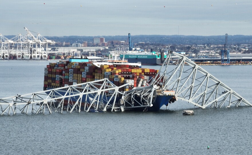 In this aerial image, the steel frame of the Francis Scott Key Bridge sits on top of a container ship after the bridge collapsed in Baltimore on March 26. It collapsed after being struck by the Singapore-flagged Dali container ship, sending multiple vehicles and people plunging into the frigid harbor below.