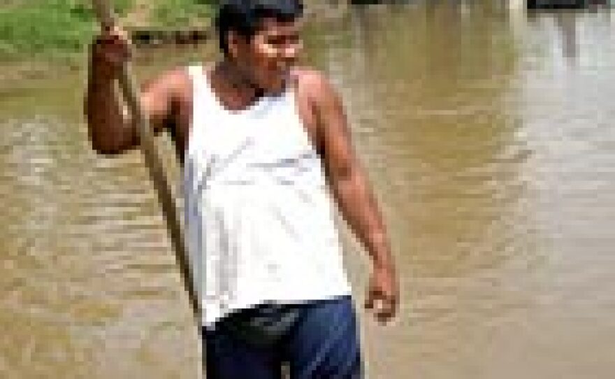 A poleman has a laugh as he bumps another raft on the muddy Suchiate River between Guatemala and Mexico. Each year several people are killed here in disputes over contraband.