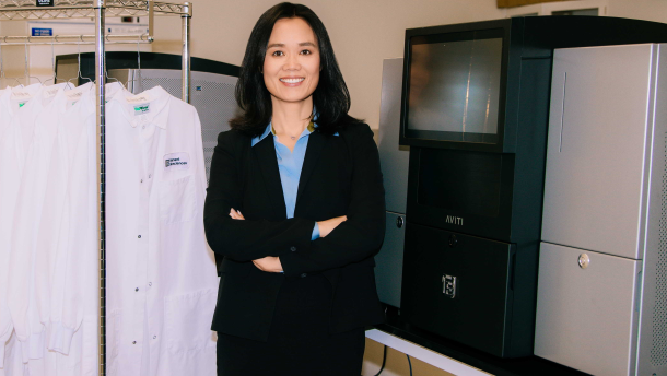 CEO Molly He of Element Biosciences stands beside the company's AVITI gene and cellular scanning device on  July 28, 2025.