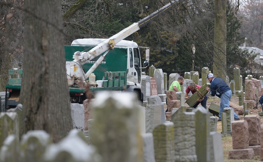 Volunteers from a local monument company help to reset vandalized headstones on Feb. 22 at Chesed Shel Emeth Cemetery in University City, Missouri, a St. Louis suburb. Since the beginning of the year, there has been a spike in incidents around the country, including bomb threats at Jewish community centers and reports of anti-Semitic graffiti.