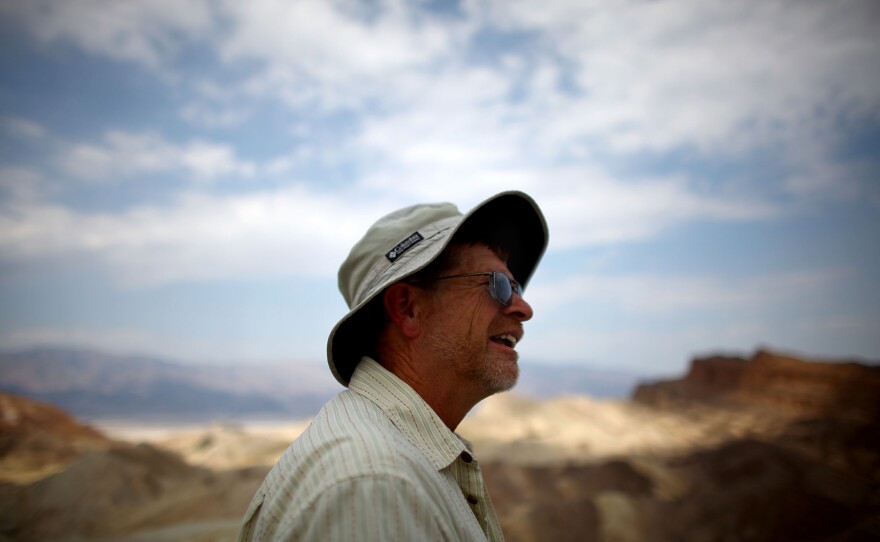 Charlie Callagan, a Death Valley National Park Ranger, stands near the bluffs overlooking Badwater Basin. Tourists come to experience temperatures they can't back home, Callagan says.