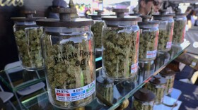 Large jars of marijuana are on display for sale at the Cali Gold Genetics booth during the High Times Cannabis Cup in San Bernardino, Calif. 