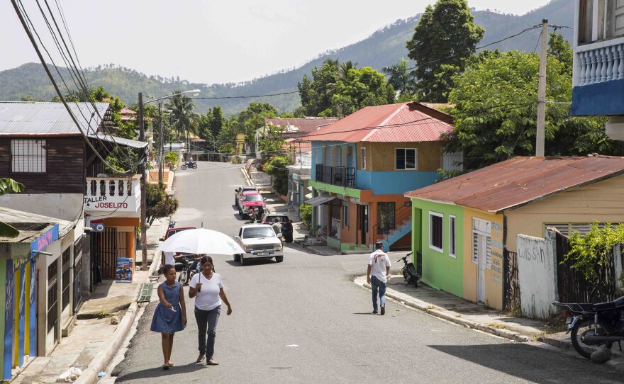 People walk down a street in Loma de Cabrera, Dominican Republic. In many ways, the Parsley Massacre remains a historical footnote in the country, seen as an uncomfortable reminder of a brutal past.