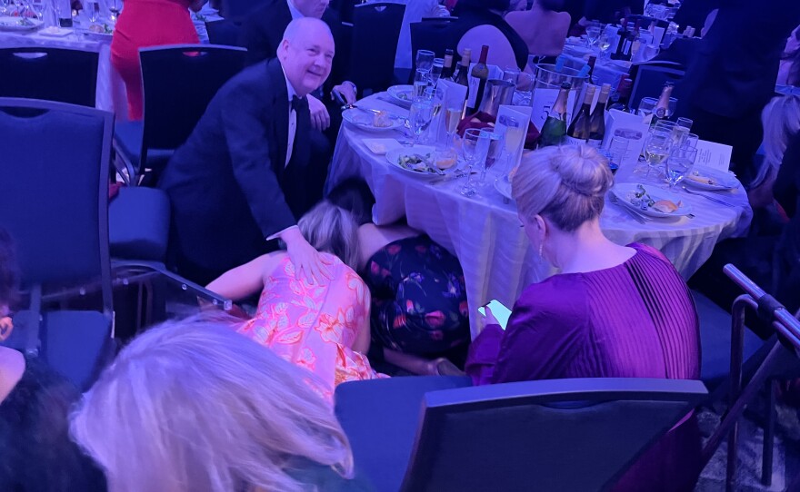Attendees at the White House Correspondents' Dinner hide under tables after reports of gunshots at a security screening area at the Washington Hilton hotel on Saturday.