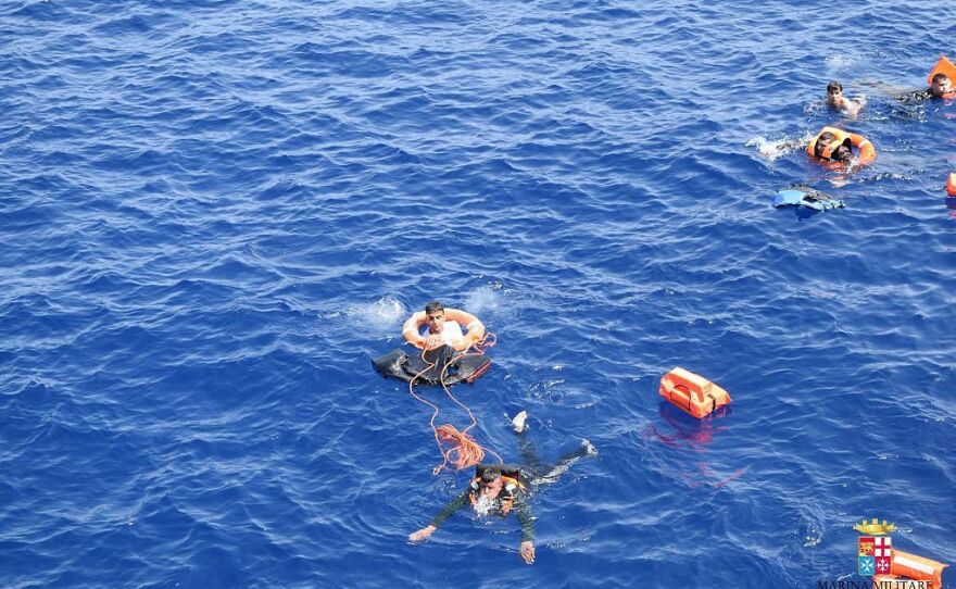 Italian marines rescue migrants from the capsized boat.
