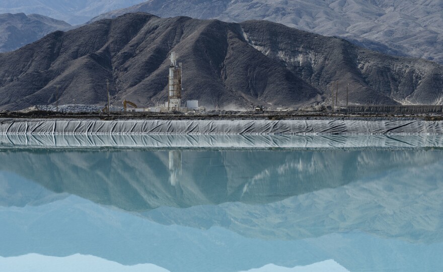 The mountains are reflected in a lithium brine evaporation pool at Silver Peak lithium mine in Silver Peak, Nev. on Oct. 6, 2022.