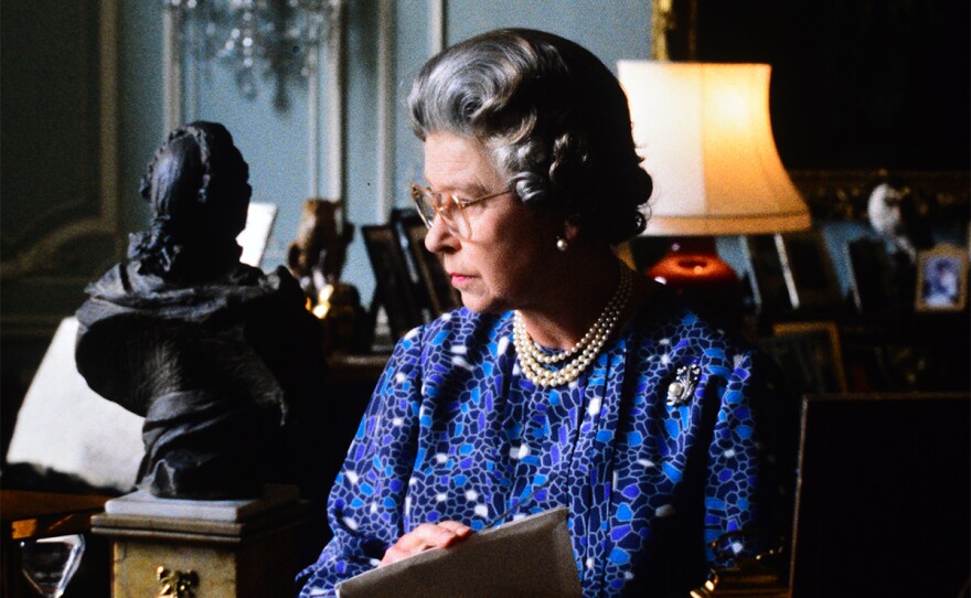 Her Majesty The Queen opening correspondence at her desk in the blue drawing room at Buckingham Palace. March 1991.