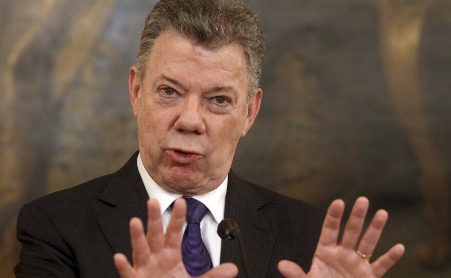 Colombia's President Juan Manuel Santos has suspended peace negotiations with the nation's last rebel group after a series of deadly bomb attacks.