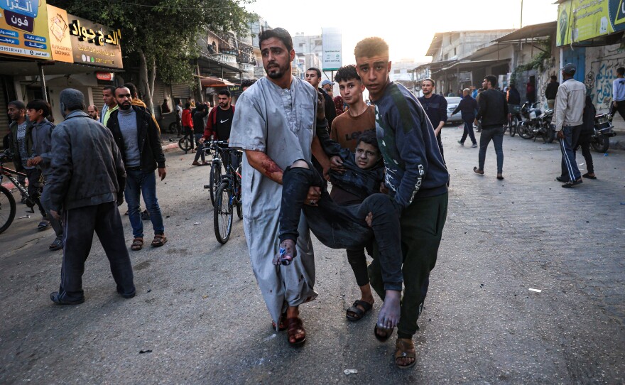 Palestinians help a boy injured in an Israeli strike in Rafah, in the southern Gaza Strip, on Dec. 3.