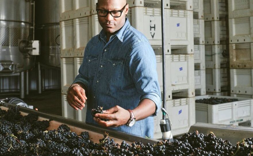 Andre Mack looks at grapes.