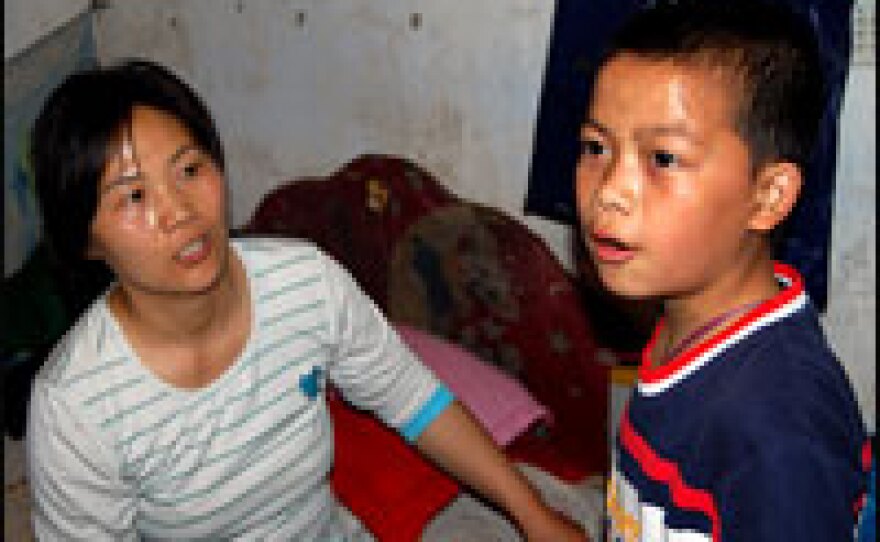 Lin Bo (right), 11, is growing up in a neighborhood of two-story houses that share courtyards. He's learning English at school. His aunt Yi Bin (left) is envious of his progress. Her son lives with his grandparents in a rural village where the schooling isn't as good.