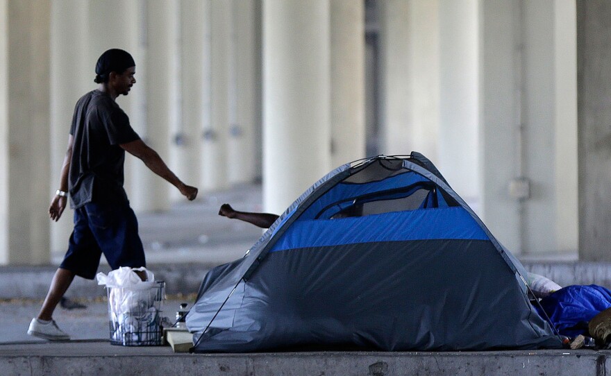 Homeless people greet one another under the Pontchartrain Expressway overpass in New Orleans on Aug. 13, 2014. The city health department put up notices that month giving the estimated 150 homeless people 72 hours to leave the area.