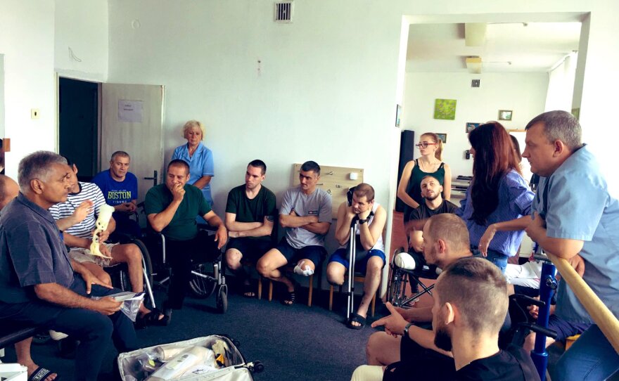 Dr. Manoj Manga (far left) speaks to staff and amputees at a Ukrainian rehab hospital. July 2022.