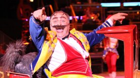 Luciano Anastasini, an 8th generation circus performer. Anastasini returns to the circus ring as a bumbling buffoon of a ring master, who tries unsuccessfully to corral his multiple mischievous puppies. Anastasini and his wife, Gladis, come from generations of Italian-American circus performers. They had their own flying trapeze act before Luciano suffered a career-ending injury in the mid-1990s. 