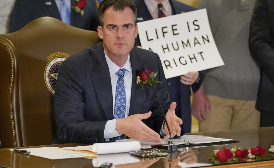 In Oklahoma City, Republican Gov. Kevin Stitt speaks after signing into law April 12, 2022, that makes it a felony to perform an abortion, punishable by up to 10 years in prison. Stitt is up for reelection in November.