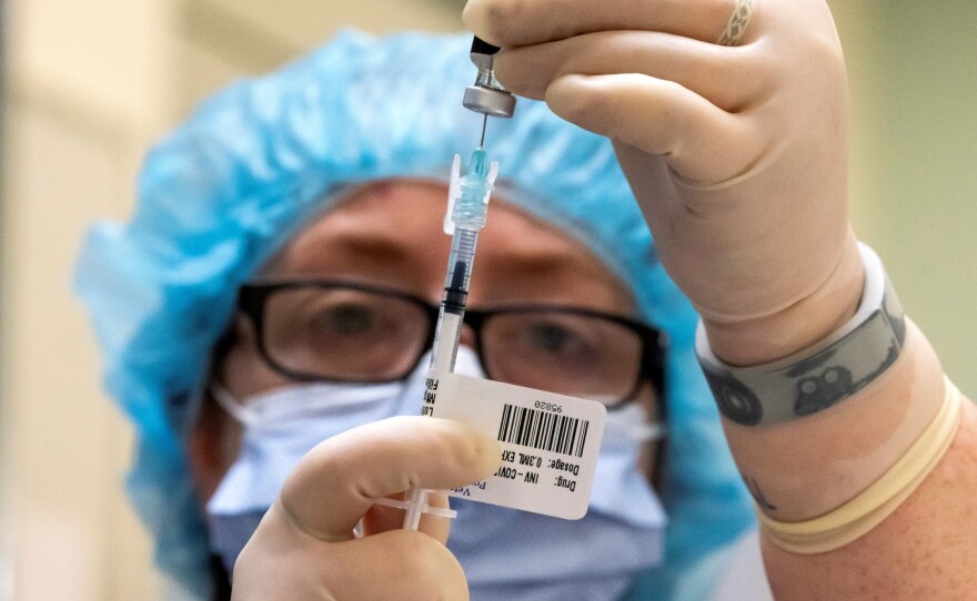 A health care worker prepares COVID-19 vaccine doses at the Portland Veterans Affairs Medical Center on Dec. 16 in Portland, Ore. Hospitals across the U.S. began getting their first doses of Pfizer's vaccine this week.
