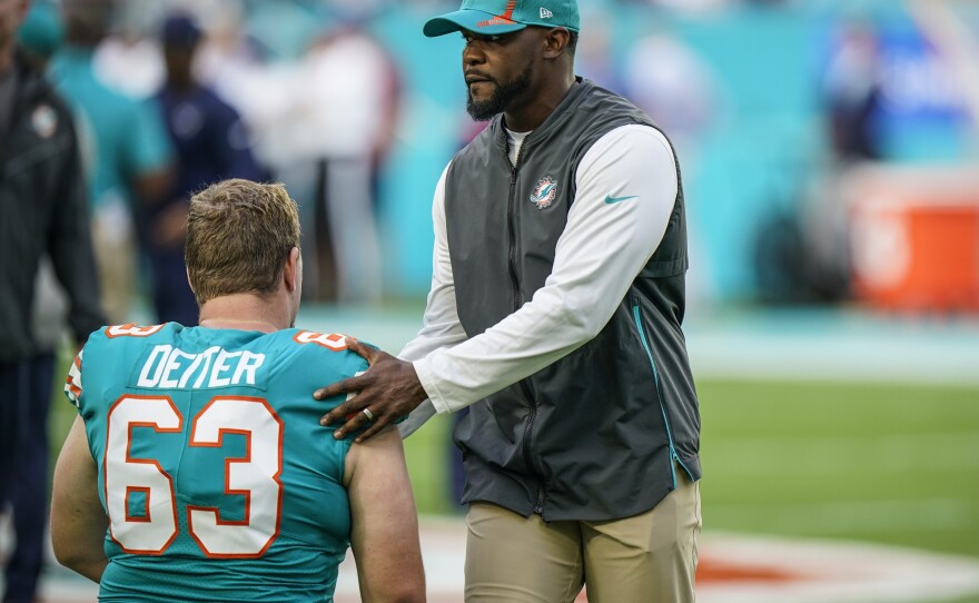 Then-head coach Brian Flores talks with Miami Dolphins center Michael Deiter before  the start of their game against the Patriots on Jan. 9.