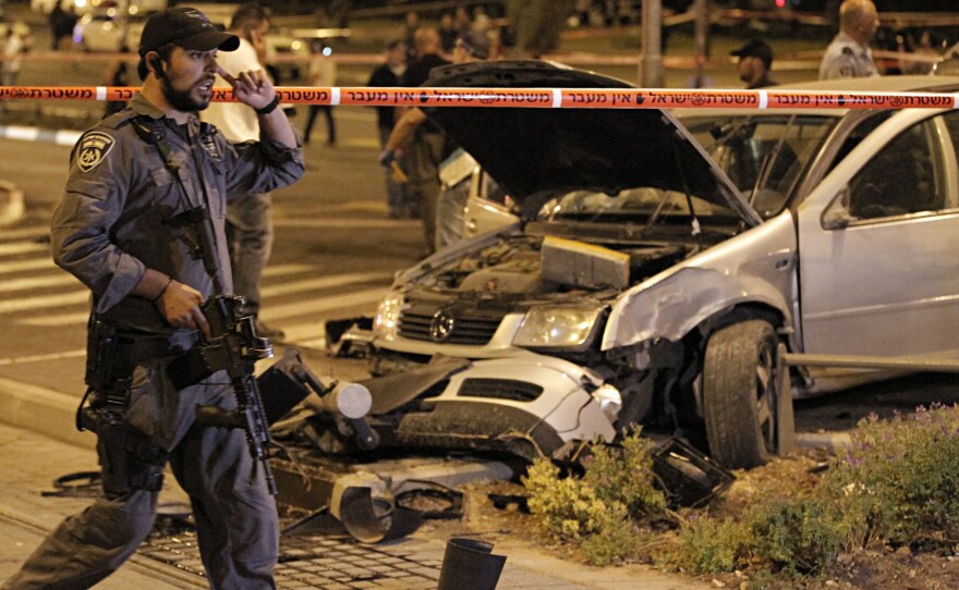 Israeli policemen secure the scene after Shaludi drove into a group of pedestrians in east Jerusalem on Oct. 22.