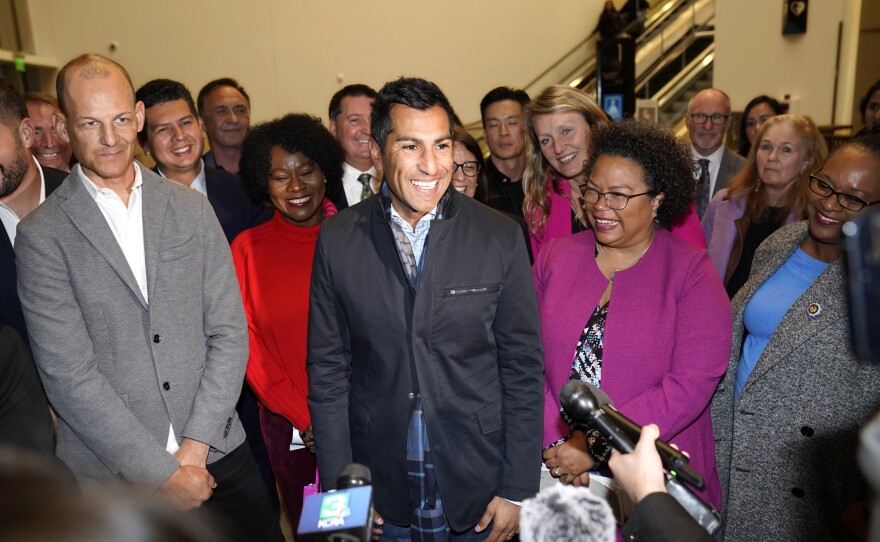 Surrounded by members of the Assembly Democratic Caucus, Assemblyman Robert Rivas, D-Hollister, center, smiles as he meets with reporters after being elected Speaker-Designee on Thursday, Nov. 10, 2022.