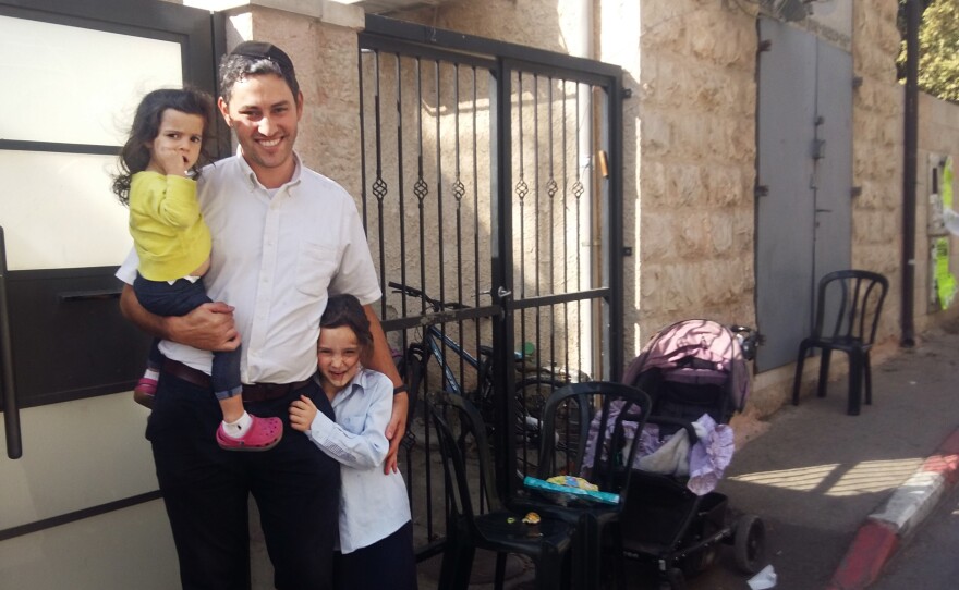 Yoself Eharman, 33, with his children, stands in front of their home in an ultra-Orthodox enclave of Jerusalem. Eharman recently left the Jewish seminary, or yeshiva, where he had studied since childhood, to train as an electrical engineer. He is now working in a solar energy company.
