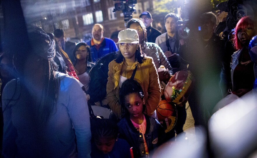 People attend a candlelight vigil in memory of 9-year-old Tyshawn Lee outside his father's home in Nov. 2015 in Chicago, Ill.