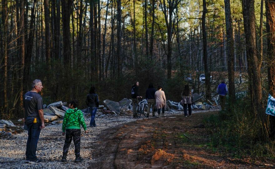 Family members of environmental activist Manuel Esteban Paez Terán visit a makeshift memorial for Terán on Feb. 6 at the site of the proposed police training facility.