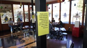 A sign advising patrons to maintain social distancing is posted in the indoor dining area of the San Francisco Deli in Redding, Calif., Thursday, Dec. 3, 2020. 