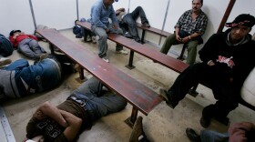 Illegal immigrants sit in a Customs and Border Patrol detention facility after being detained October 17, 2007 in Campo, California. 