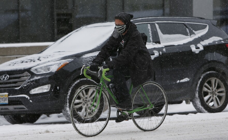Traffic slowed in downtown Denver on Wednesday as snow fell on the city.