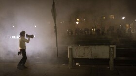 A protester confronts police in front of the Brooklyn Center Police station on Sunday, April 11, 2021, in Brooklyn Center, Minn.