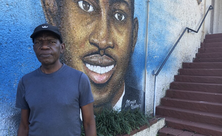 Marvin Weeks in front of his mural of Ahmaud Arbrery.