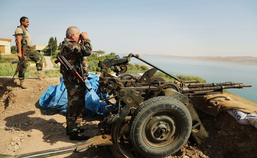 Kurdish forces, known as peshmerga, stand guard near the Mosul Dam on Aug. 17. U.S. airstrikes against the Islamic State allowed the peshmerga to move in and take the area around the dam recently.