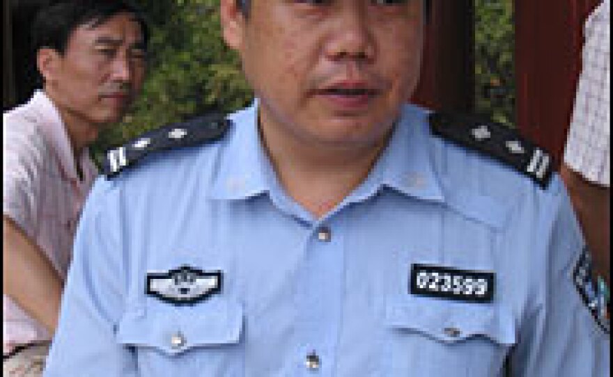 Police officer Liu Wenli enjoys practicing his language skills with foreign tourists as he patrols Coal Hill Park.