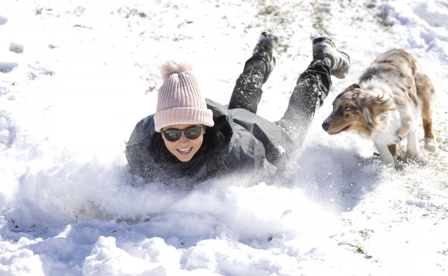 Megan Pennartz and her dog Jensen go sledding in Fort Worth, Texas, on Monday.