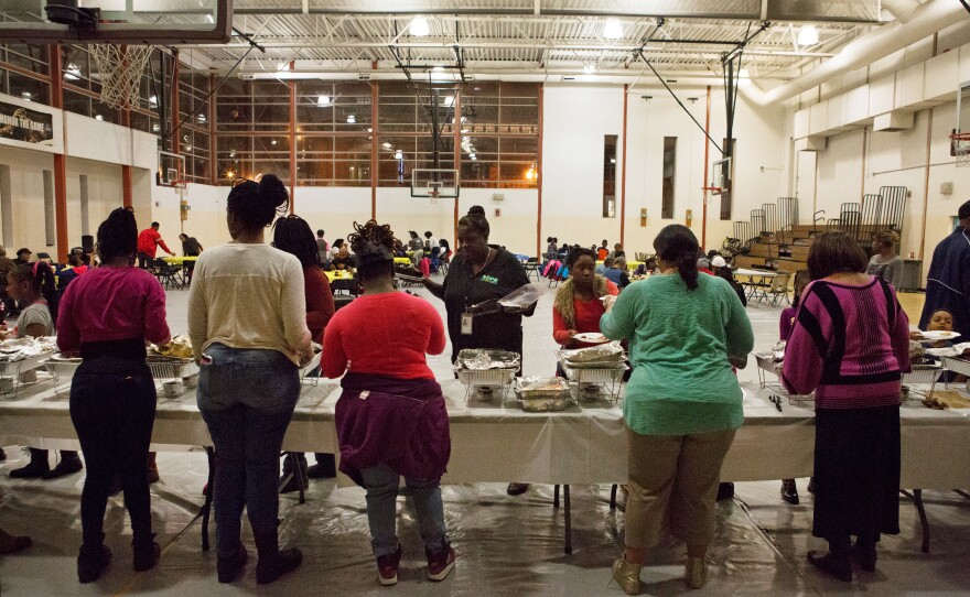 Residents line up for a Thanksgiving meal in a community gathering at Kennedy Recreation Center in Shaw.