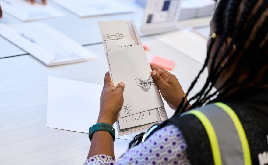 A Wake County Board of Elections employee prepares a mail-in ballot to be sent out to a voter in September in Raleigh, N.C.