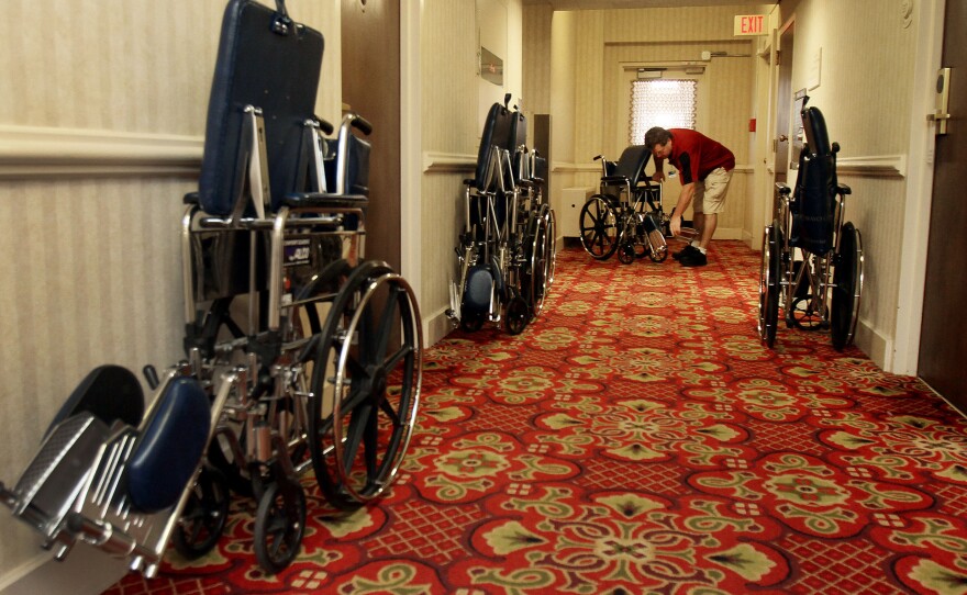 Mayo Clinic employee Kevin Acker collects wheelchairs from a hallway at the Kahler Grand Hotel in Rochester. He retrieves abandoned chairs around the city every weekend.