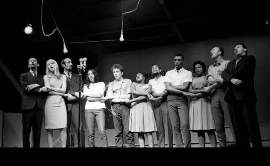 L-R: Peter, Paul and Mary, Joan Baez, Bob Dylan, the Freedom Singers, Pete Seeger and Theodore Bikel sing “We Shall Overcome” at the 1963 Newport Folk Festival.