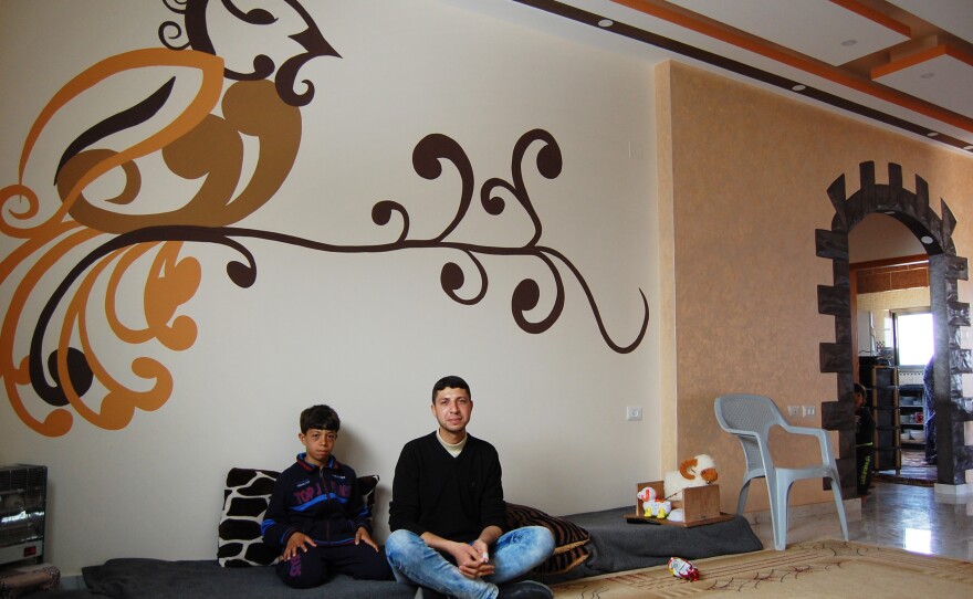 Hytham Harara, 21, sits with his little brother in their recently reconstructed home in Gaza City. The family returned home a couple months ago, after a year-and-a-half crammed into a rental.
