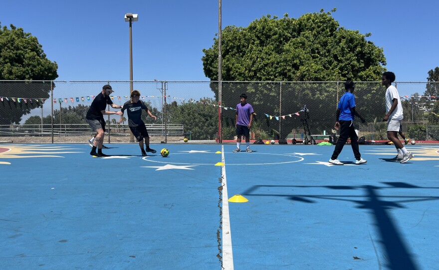Youth  players practice a soccer drill at Colina Del Sol Park's basketball courts, July 10, 2025.