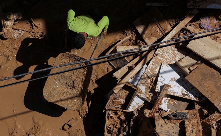 A person removes mud from a house after floods in Derna, Sept. 19.
