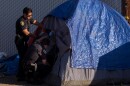 San Diego Police officers beginning a policy of progressive enforcement for people living in a homeless encampment on Sports Arena Boulevard, Feb. 14, 2022.