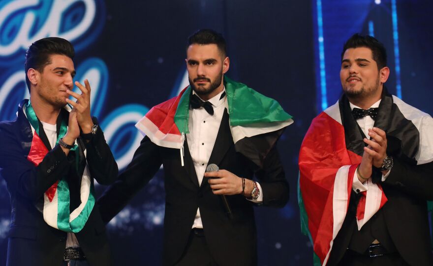 Palestinian Arab Idol TV show winners Yaacoub Shahin (center), Ammar Mohammed (left) and Amir Dandan stand on stage during the final in the pan-Arab song contest on Feb. 25, 2017 at MBC studios in Zouk Mosbeh, north of Beirut.