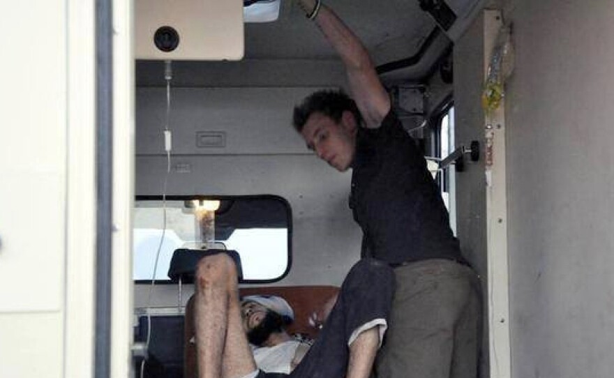 Kassig, right, works as a medic to help a wounded man near the Syrian town of Deir Ezzor. A trained emergency medical technician, Kassig provided  aid through the group he founded, the Special Emergency Response and Assistance (SERA).