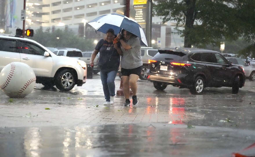 Fans make their way into Minute Maid Park as a severe thunderstorm hit before a baseball game between the Oakland Athletics and the Houston Astros, Thursday, May 16, 2024, in Houston.